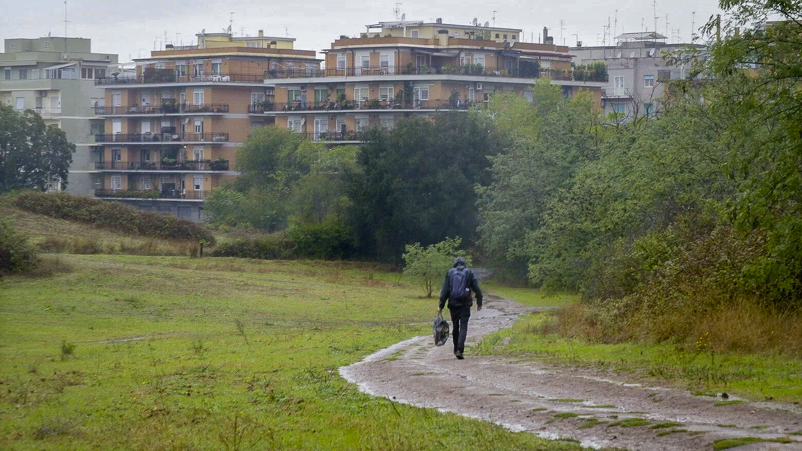 Artist walking through Tor Marancia with apartment buildings behind